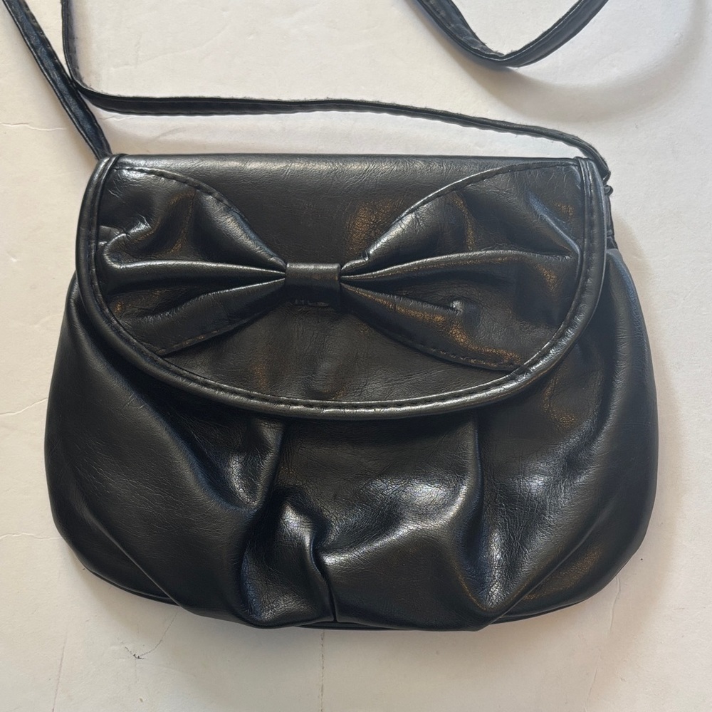 BLACK CROSSBODY…FAUX LEATHER…BOW DESIGN…LONG STRAP NON ADJUSTABLE…HOLDS A LOT